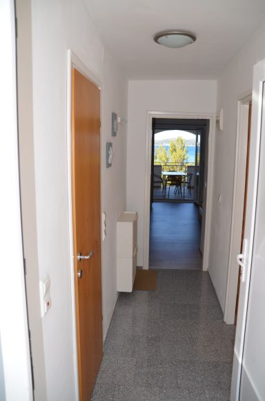 Eingangsbereich Heller Flur mit Holz- und weißen Türen, führt zu einem Balkon mit Aussicht.