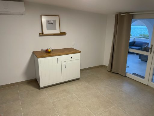 Separater Küchenschrank Helle, Wohnung mit einem weißen Sideboard und einer Eingangstür zum Außenbereich.