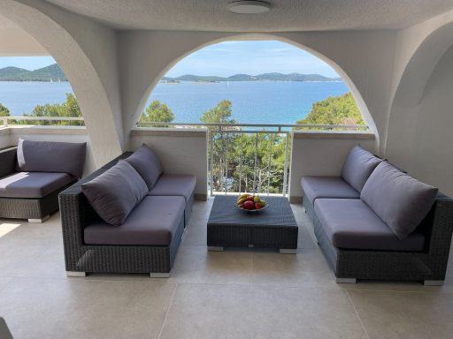 Loungebereich Moderne Sitzgruppe mit Meerblick und Obstschale auf dem Tisch.
