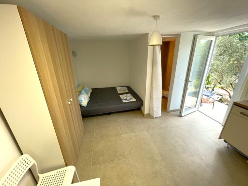 Schlafbereich Helle, moderne Wohnung mit Bett, Kleiderschrank und Zugang zur Terrasse.