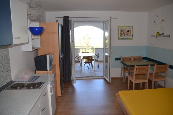 Küche/Schlaf/Essbereich mit Blick auf´s Meer Kleine Küche mit Esstisch und Zugang zu einer Terrasse mit Aussicht.