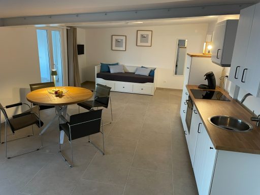 Küche, Esszimmer innen und Ausziehbett Helle, moderne Wohnküche mit Essbereich, Schlafsofa und Aussicht auf Fenster.